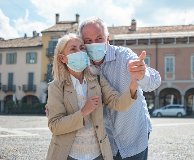 Casal de idosos se divertindo ao ar livre durante a pandemia de coronavírus