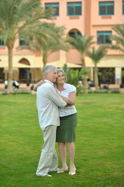 Casal de idosos se divertindo no jardim do hotel tropical