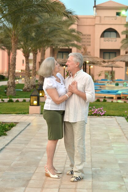 Casal de idosos se divertindo no jardim do hotel tropical