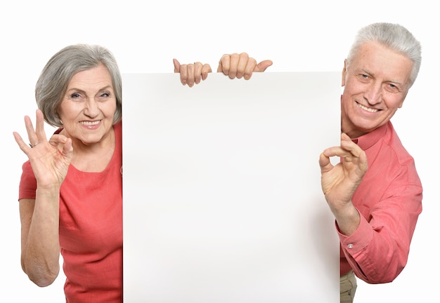 Casal de idosos segurando um banner em branco sobre um fundo branco