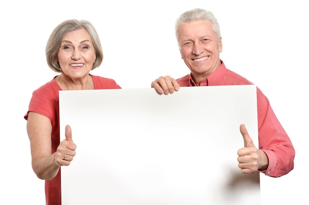 Casal de idosos segurando um banner em branco sobre um fundo branco