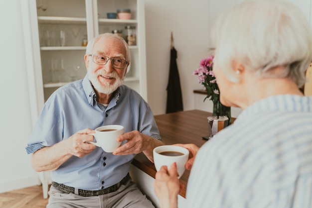 Casal de idosos tomando café da manhã em casa - vida cotidiana de idosos