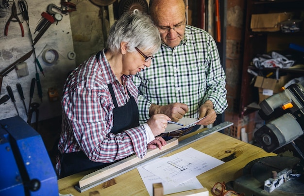 Foto casal de idosos trabalhando em uma oficina de carpintaria