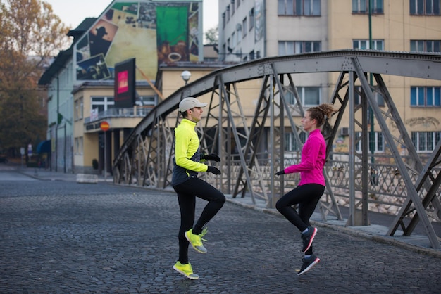 casal de jogging se aquecendo e se alongando antes da corrida matinal na cidade