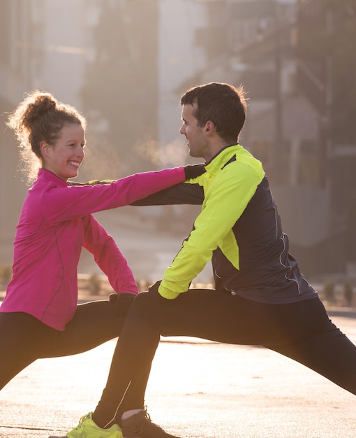 casal de jogging se aquecendo e se alongando antes da corrida matinal na cidade