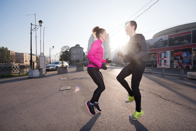 casal de jogging se aquecendo e se alongando antes da corrida matinal na cidade
