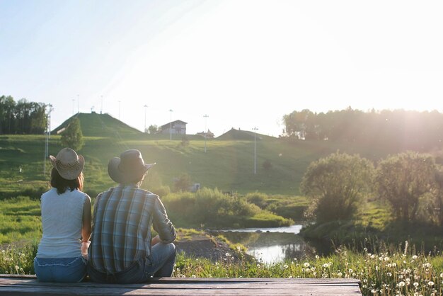 Casal de jovens admira o pôr do sol na noite de primaveraxA