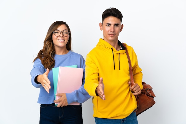 Casal de jovens estudantes em branco apertando as mãos para fechar um bom negócio