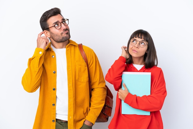 Casal de jovens estudantes isolado no fundo branco pensando em uma ideia enquanto coça a cabeça