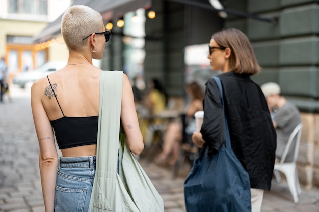 Casal de lésbicas elegantes andando na rua