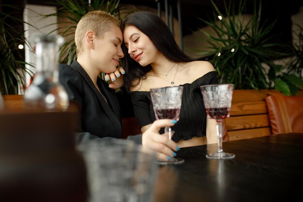 Casal de lésbicas em um encontro em um restaurante bebendo vinho