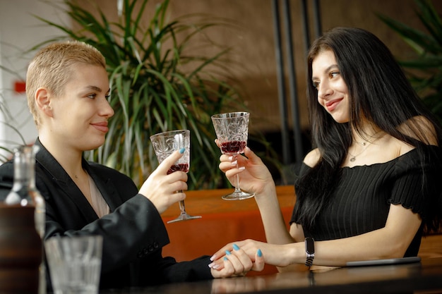 Casal de lésbicas em um encontro em um restaurante bebendo vinho