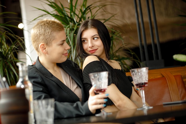 Casal de lésbicas em um encontro em um restaurante bebendo vinho