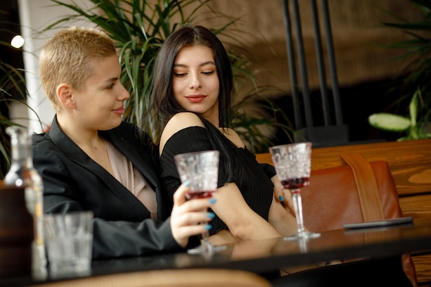 Casal de lésbicas em um encontro em um restaurante bebendo vinho