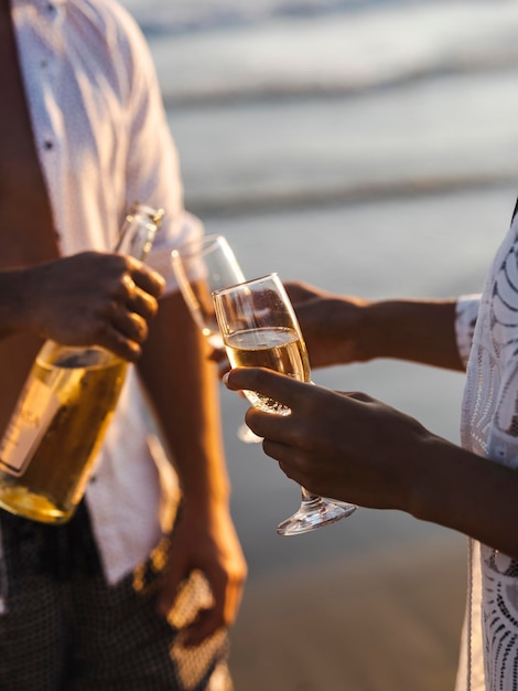 Casal de lua de mel bebendo champanhe na praia tropical