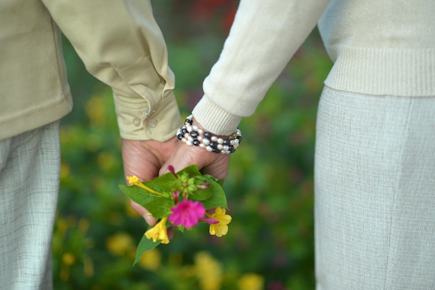 Casal de mãos dadas com flores