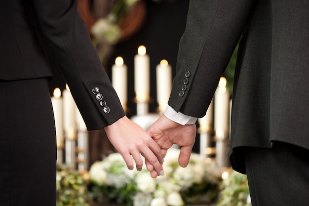 casal de mãos dadas em um funeral