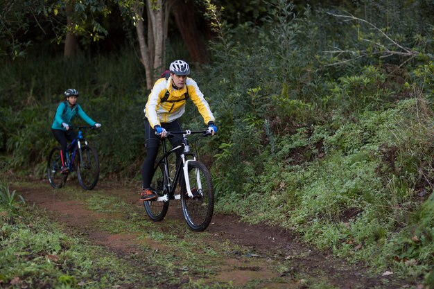 Casal de motociclistas ciclismo na zona rural