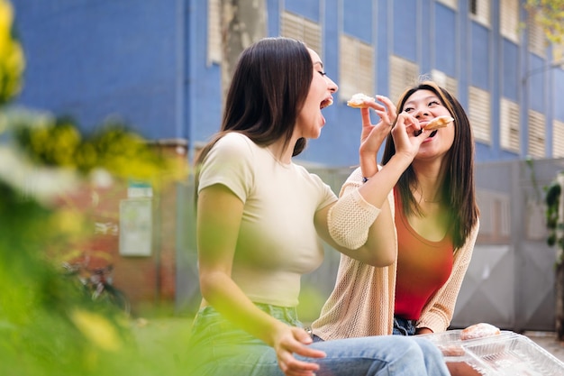 Casal de mulheres jovens compartilhando alguns pães doces