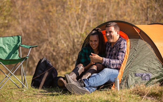 Casal de namorados sorrindo na frente da tenda. Pessoas felizes felizes