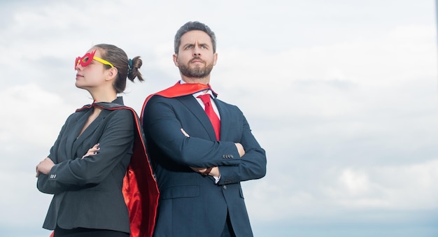 Casal de negócios em traje de super-herói na motivação do fundo do céu