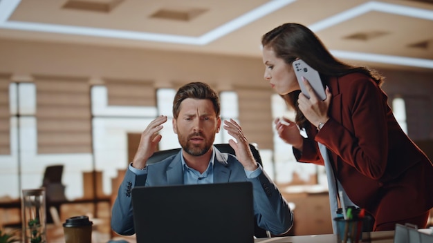 Foto casal de negócios estressado a trabalhar num grande gabinete. mulher nervosa a ligar para o smartphone.