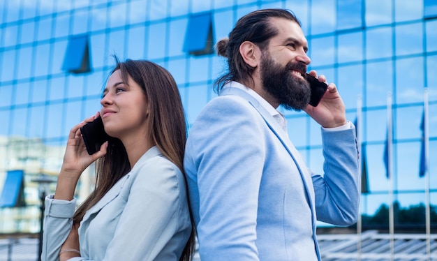 Casal de negócios fala na comunicação ao ar livre por telefone