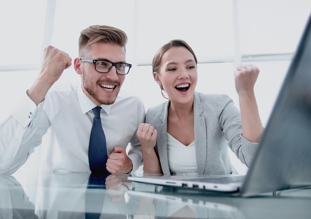 Casal de negócios feliz sentado em sua mesa