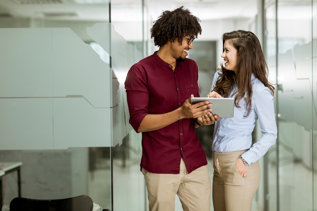 Casal de negócios multiétnico usando um tablet digital no escritório