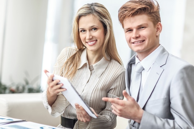 Casal de negócios sorridente, olhando para a tela do tablet digital.