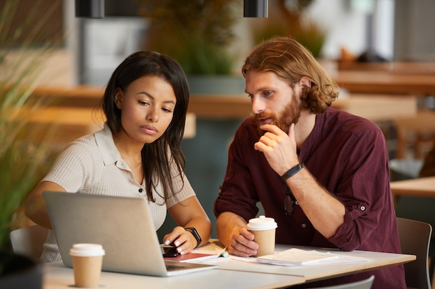 Casal de negócios usando laptop