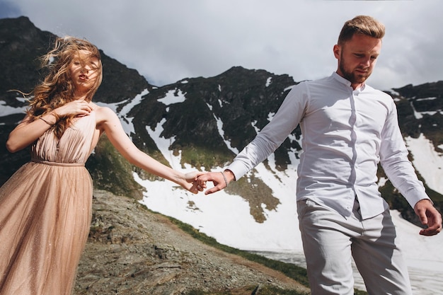Casal de noivos andando nas montanhas com vistas deslumbrantes