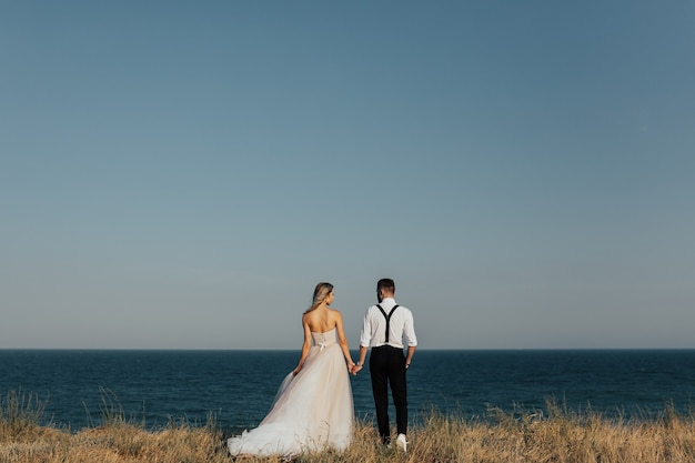 Casal de noivos felizes na praia do mar.