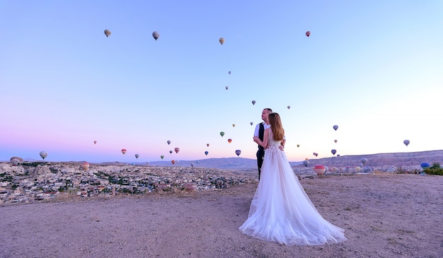 casal de noivos na capadócia Turquia com balões de ar quente