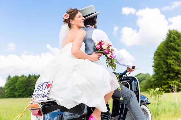 Casal de noivos na motoneta recém casada