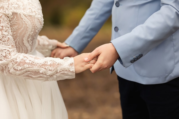 Casal de noivos, noivos de mãos dadas, lindo dia do casamento