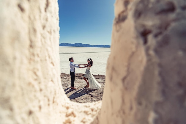 Casal de noivos posando em uma paisagem branca com acessórios