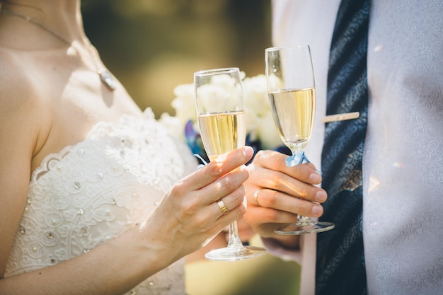 Foto casal de noivos segurando taças de vinho