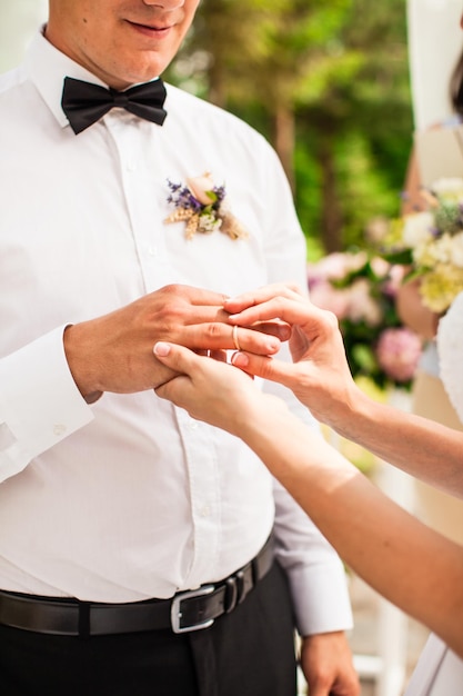 Casal de noivos sob o arco de flores na cerimônia de casamento