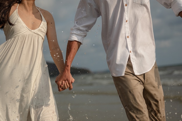 Casal de passeio romântico de férias na praia relaxando no oceano destino de viagem de verão. jovens casais