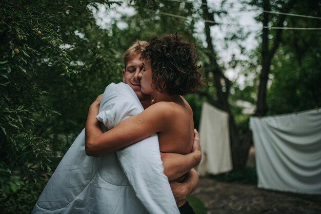 Foto casal de pé contra as árvores