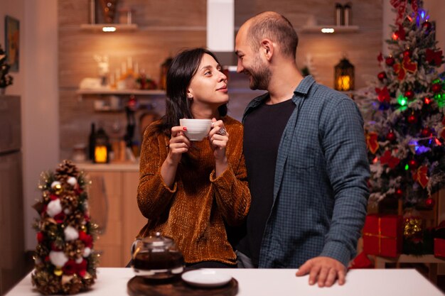 Foto casal de pé na cozinha durante o natal