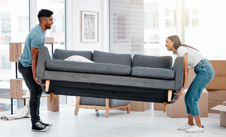 Foto casal de pessoas e sofá se mudando juntos no apartamento da sala de estar e entusiasmados com a nova casa móveis homem feliz e mulher com sofá pesado em propriedade desembalagem e realocação dentro da casa