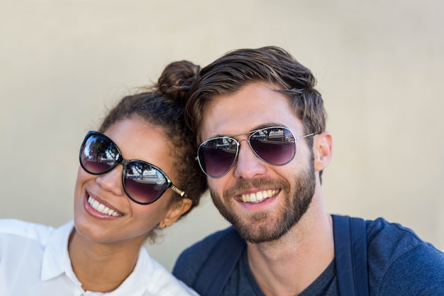 Foto casal de quadril com óculos de sol sorrindo para a câmera