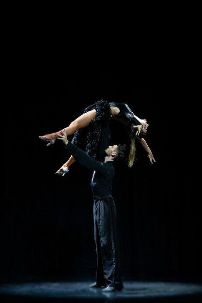 Casal de salão de baile dançando isolado no preto.