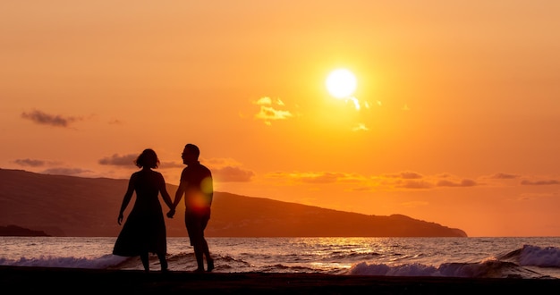 Casal de silhueta de pé na praia