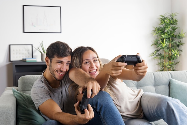 Foto casal de tiro médio com controladores competindo