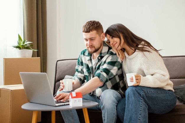 Foto casal de tiro médio olhando para um laptop