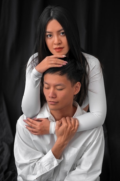 Casal de tiro médio posando no estúdio