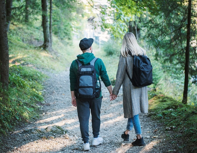 Casal de viajantes apaixonados, desfrutando na floresta. Liberdade e conceito de estilo de vida ativo. Vista traseira